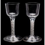 A pair of English opaque twist wine glasses: each with ogee shaped bowl on a straight double series