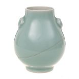 A small Chinese celadon vase: of pear shape with mask head handles and on cylindrical foot,