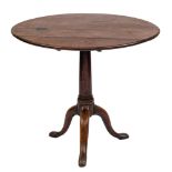 A George III mahogany circular tea table:, the snap top on a turned pillar and tripod splayed base,