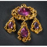 A mid 19th Century gold and foiled amethyst oval brooch: with three drops,