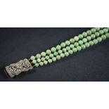 A graduated jade bead three-string necklace: the individually knotted beads graduate from 5mm to