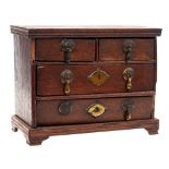 An antique miniature oak chest: of rectangular outline containing two short and two long drawers on