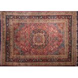 A Meshed carpet:, the shaded wine cartouche field with a central indigo pole medallion,