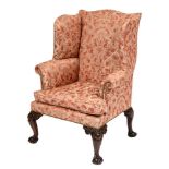An 18th Century and later carved mahogany wing frame armchair:, fully upholstered,