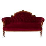 A Victorian carved walnut and inlaid settee:, of curved outline,