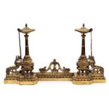 A pair of 19th Century brass chenets: the Roman style lamp with acorn finial mounted on a fluted