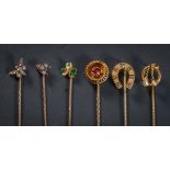 A diamond mounted stick-pin with fly motif, a stick-pin with butterfly motif,
