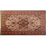 A Tabriz carpet:, the beige field with a central indigo pole medallion with palmette designs,