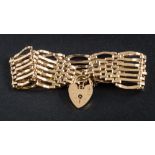 A 9ct gold seven bar, gate-link bracelet: with attached heart-shaped padlock clasp and safety chain,
