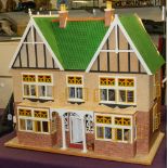 A large 20th Century doll's house with double gabled roof and fitted interior with figures and