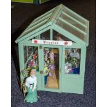 A 20th Century doll's greenhouse flower shop 'Poppies' with figure, flowers and accessories.