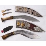 Two horn handled kukri knives: both in pressed steel decorated scabbards (2)