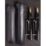 Two Pelikan P200 fountain pens in black: one with medium nib, the other with a broad nib.