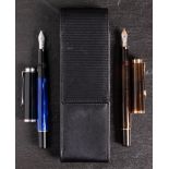 Two Pelikan (Germany) '200' piston filing fountain pens: one on smoked amber,
