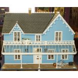 A large late 20th century Victorian style doll's house: with simulated slate roof over blue wall