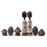 Two Mills bomb hand grenade casings together with three WWI period fuses,
