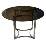 A smoked glass circular dining table on stainless steel base: with concave stretchers to top and