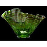 A large 'Venetian' glass bowl: possibly by Bob Crooks, the green glass body with wavy rim,