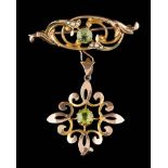 A 15ct gold, peridot and seed pearl mounted bar brooch: suspending a '9ct' stamped peridot,