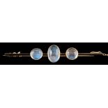 A moonstone three-stone bar brooch: set with an oval moonstone between circular moonstones,