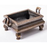 A Chinese bronze censer: of rectangular archaistic form with pierced s-shaped handles,