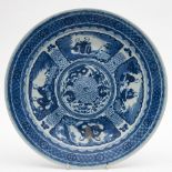 A Chinese porcelain plate: painted in blue and white with four panels containing a pair of seated