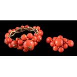 An antique coral and gilt metal hinged bangle: set with graduated coral beads set with star motif