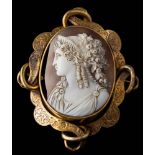A Victorian oval shell cameo brooch: within a foliate engraved openwork scroll frame approximately