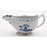 A Lowestoft blue and white sauceboat and a similar mug: the sauceboat with moulded floral and