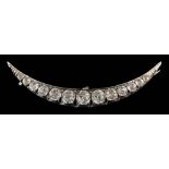 A paste set crescent brooch: with thirteen graduated white pastes, approximately 68mm long.