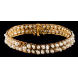 A freshwater pearl hinged bangle: with safety chain, approximately 16.5gms gross weight.
