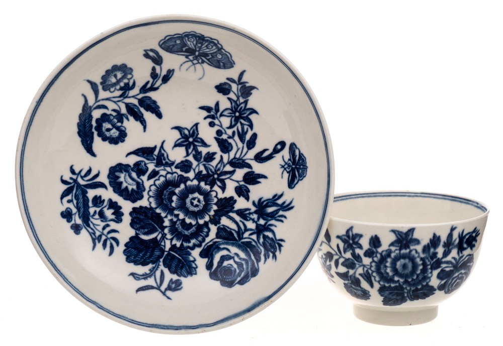 A First Period Worcester teabowl and saucer: printed in the 'Three Flowers' pattern [I.I.