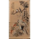 A Chinese scroll painting, signed Ding Bao: of birds perched on a flowering tree and rockwork,