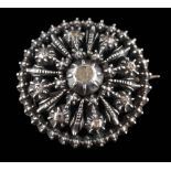 A silver circular, diamond chip brooch: of pierced design approximately 28mm diameter.