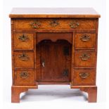 An early 18th Century walnut and cross and feather banded kneehole desk:,
