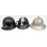 Three mid 20th century French Fire Service helmets: comprising a black steel helmet with gilt