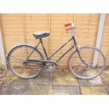 A mid 20th century Raleigh lady's bicycle: black step through frame, solid bar brakes,