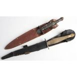 Two Fairbairn Sykes pattern knives: one with chequered brass grip in black leather scabbard,