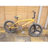 A Diamondback Session BMX bike:, yellow frame with black front forks and handlebars, lever brakes,