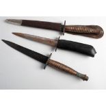 Two Fairbairn Sykes pattern knives: Third Pattern with cast ribbed grip, in brown leather scabbard,