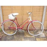 A 1960s Triumph 'Palm Beach' lady's bicycle: two tone red & white step through frame with remains