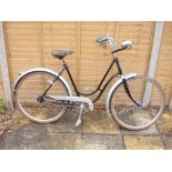 An early 20th century Peugeot lady's bicycle: the black step through frame with silver painted bars,