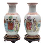 A pair of Chinese famille rose baluster vases: each painted with a presentation scene depicting an