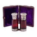 A Victorian silver and ruby glass double ended scent bottle, unmarked: of cylindrical outline,