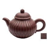 A Chinese Yixing teapot and cover: of ovoid form moulded as a chrysanthemum flower with bud finial,
