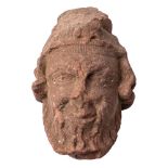 A carved sandstone head of a bearded man: wearing a coronet, with wavy hair, 23cm high.