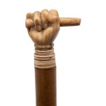 A 19th century marine ivory walking cane,: the pommel carved in the form of a fist holding a bar,