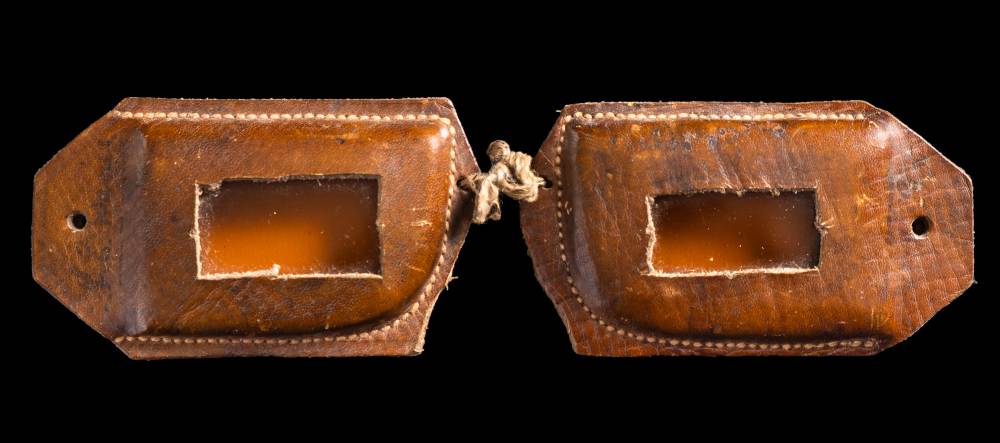 A pair of handmade stitched brown two piece leather snow goggles used by F E C Davies aboard the