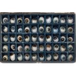 An Optician's case of fifty glass eyes: in blues, greens and brown colours,