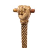 A 19th century marine ivory walking cane with carved pommel in the form of a fist holding a
